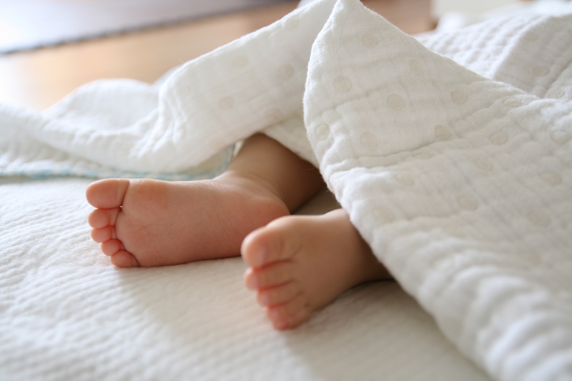 布団で眠る赤ちゃんの足